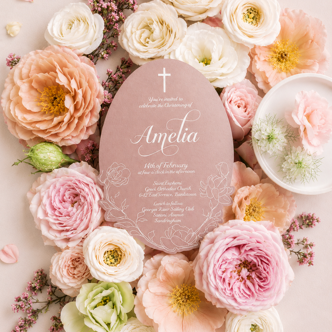 Pink floral invitation card surrounded by pink and white flowers on a light pink background