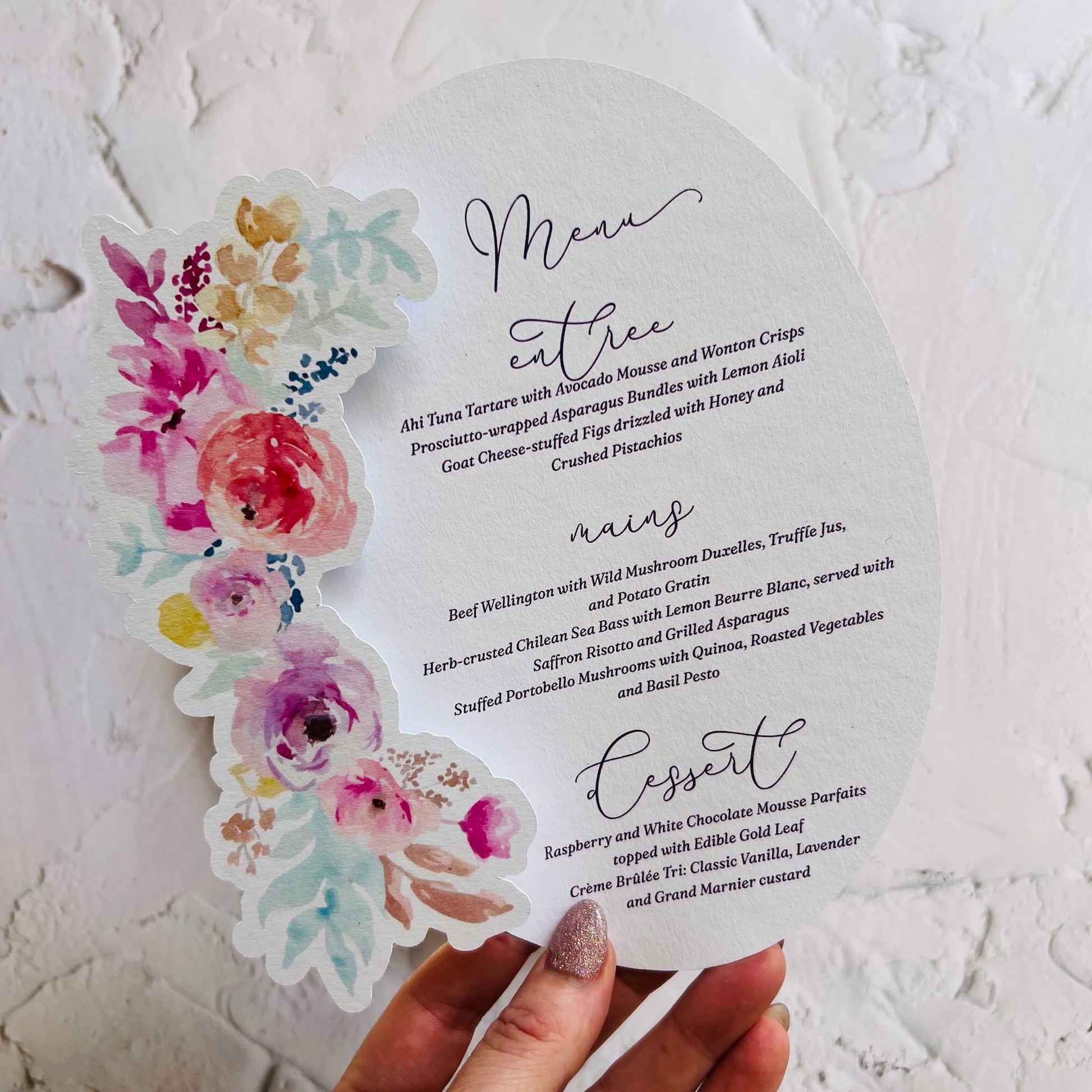 Menu card with floral design held by a hand on a textured white background
