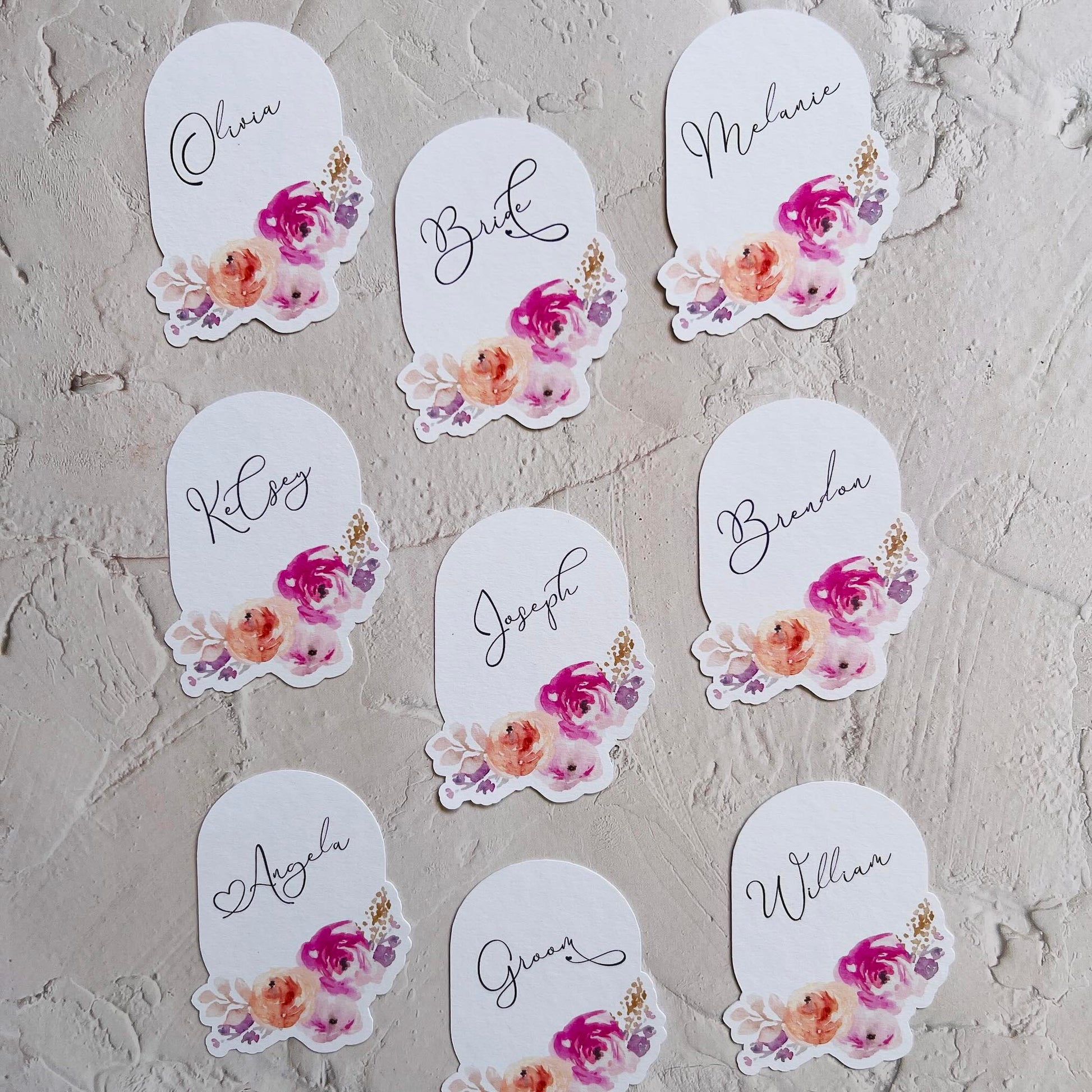 Set of name tags with floral designs on a textured surface