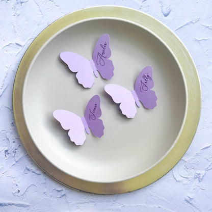 Butterfly-shaped name cards on a round plate with a light background