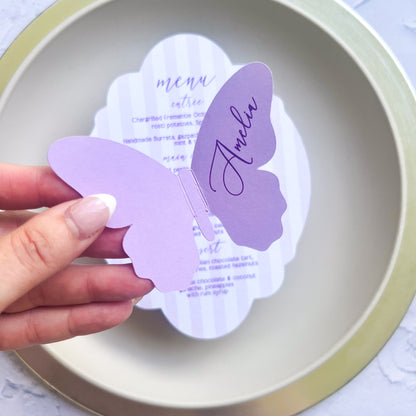Butterfly-shaped wedding place card with 'Amelia' on a white plate
