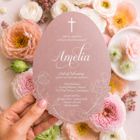 Invitation card held over a floral background with 'Amelia' written on it