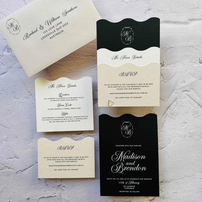 Wedding invitation set with black and white design on a textured surface