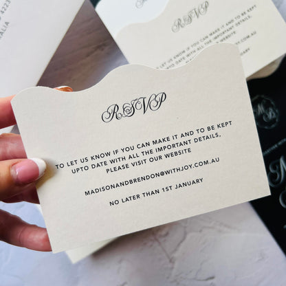 Hand holding an RSVP card with wedding details