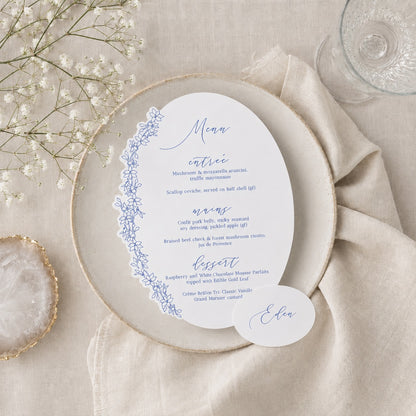 Menu card with floral design on a beige plate with a beige napkin and flowers. with place card