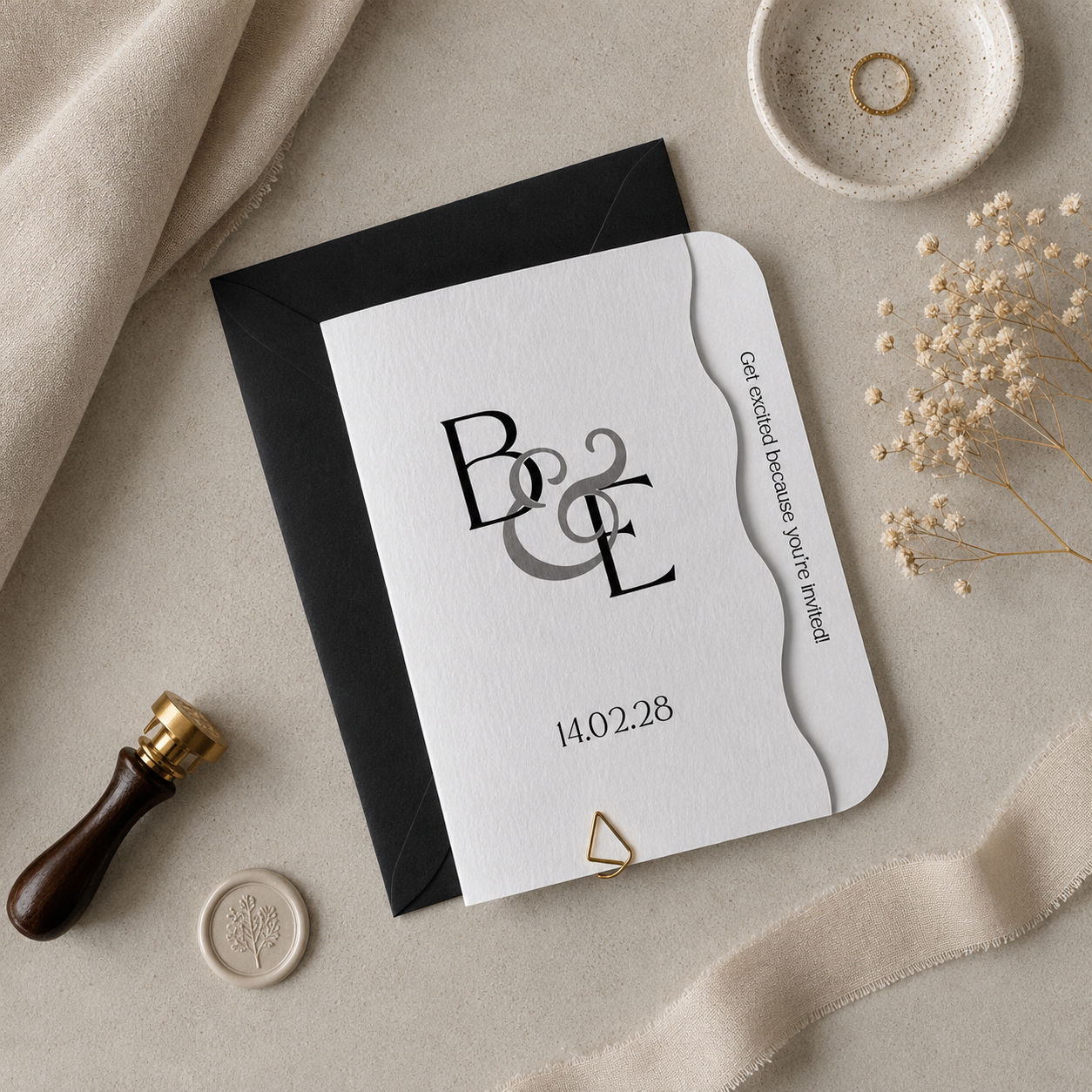 Wedding invitation with monogram and date on a beige surface with decorative elements.
