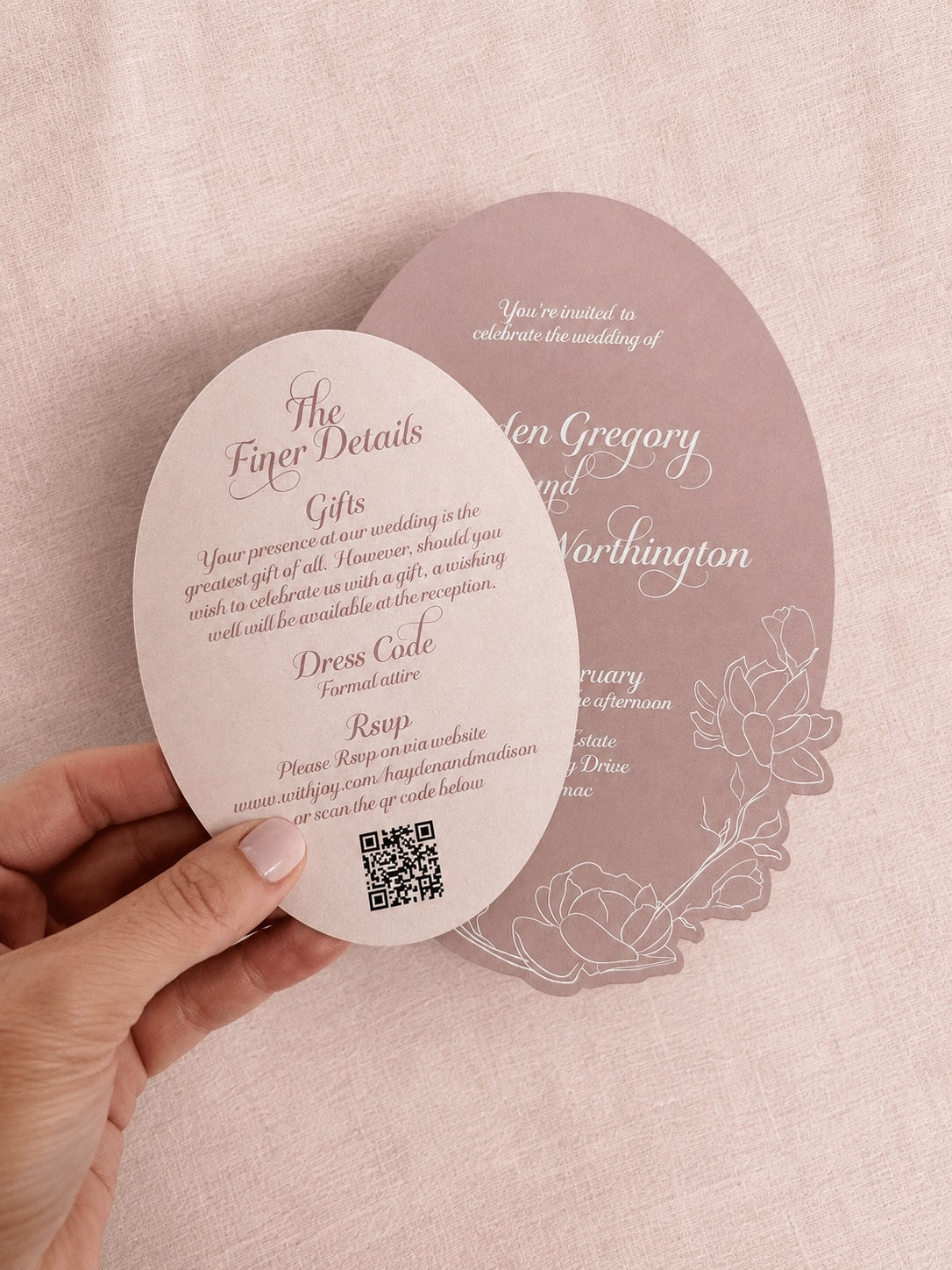 Round wedding invitation card held by a hand with a QR code on a matching background